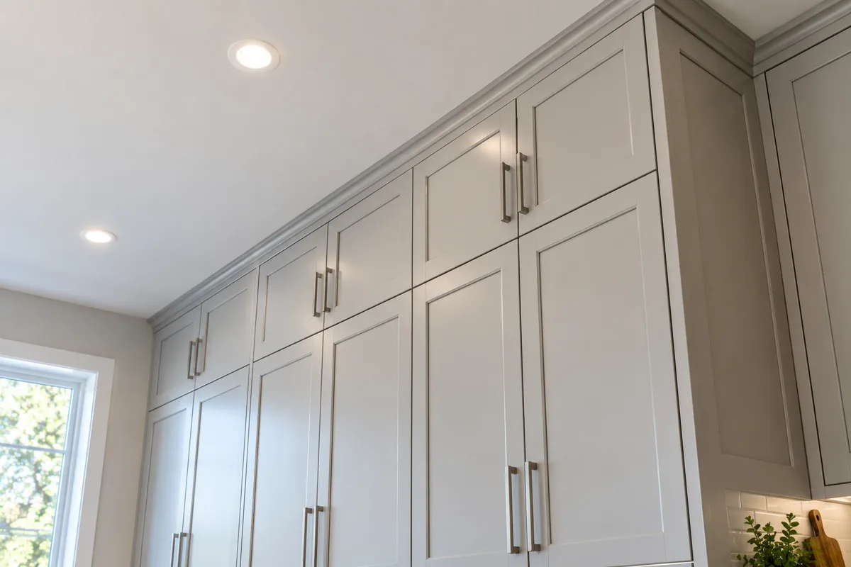 Wall cabinets run to the ceiling with no soffit above them, seen from below at the join